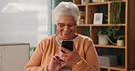 Senior, happy woman and typing with phone for online bingo, research or browsing at home. Elderly female person or smile on mobile smartphone for social media, word search or game at retirement house