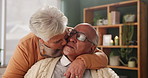 Senior couple, relax and kiss in house with love in retirement for marriage, happiness and funny. Elderly people, affection and smile on sofa in living room with care, support and trust for bonding