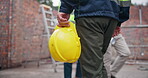 Back, worker and walking in construction site as engineer, project manager or supervisor for handshake. Person, hardhat and property development for apartment building, real estate and city planning