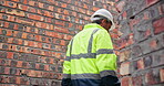Back, man and walking in building construction as engineer, project manager or supervisor for site inspection. Worker, hardhat and property development for apartment building, real estate or planning