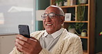 Senior man, relax and typing on phone in house with happiness for conversation, funny and good news. Elderly person, smartphone and speak with smile or excited for gossip, chat and invite to reunion