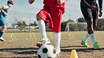 Boy, ball and training for soccer on field with coaching, kick and running in cone with fitness. Football club, child and legs for match workout, drill and player on grass for sport and exercise