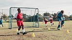 Boy, children and exercise on field for soccer with resistance band, harness and running for speed with development. Coach, man and kids in football with team, cone and diversity for fitness on grass