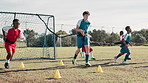 Boy, children and workout on field for soccer with resistance band, harness and running for speed with development. Coach, man and kids in football with team, cone and diversity for fitness on grass