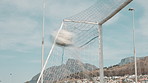 Outdoor, football field and ball with goal in net for practice, training or precision in penalty. Blue sky, clouds and post with score in game for sports competition, tournament or accuracy in Brazil