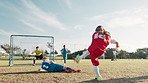 Football, player and children in stadium for shooting, practice and exercise for sport competition. Soccer field, goalkeeper and kids athletes for training, kick and motor coordination with scoring