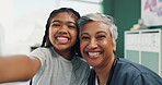 Girl, child and happy with doctor for selfie with funny face, positive experience and peace sign in hospital. Mature, female general practitioner and young patient with photography for documentation.