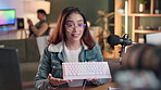 Broadcast, keyboard and live stream with woman content creator in office for review on podcast or radio. Camera, microphone and product with happy influencer talking to audience of online followers