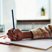 Alphabet, child and hand on desk, writing and closeup of education ...
