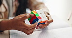 Color, cube and puzzle on hands, game and closeup of student in classroom with notebook and desk. Middle school, growth and development of child with challenge of pattern, solving and goal for kid