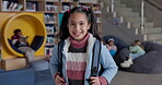 Young girl, face and backpack at school library and happy for education, development and studying. Student, smile and portrait with bag in lobby for learning, growth and start at academy in New York 