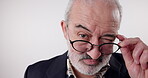 Senior man, portrait and glasses with wink, studio and hush for mystery announcement. Mature model, gossip and secret with rumor, whisper and gesture for news or emoji for privacy on white background