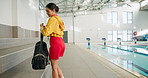 Swimming pool, sports and woman in gym with bag to start workout, exercise and lifeguard training. Swimmer, happy and person for fitness, practice and safety class for wellness, health or competition