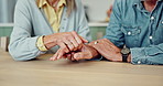 Senior couple, support and holding hands on table, home and closeup of commitment, trust and empathy. Lounge, care and comfort for fraud of pension, elderly people and compassion in house and love