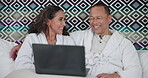 Couple, laptop and relax on bed with laughing in hotel for comedy movie and watching funny video in robes. People, happy and technology in bedroom of accommodation for film, holiday and conversation