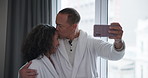 Happy couple, relax and kiss with selfie at resort for memory, photography or moment at indoor hotel. Young man and woman with smile or hug for picture, love or honeymoon together at luxury resort