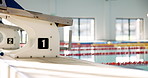 Empty, starting blocks and pool for swimming with exercise, professional competition and diving for race event. Training arena, water and platform for jumping with aquatic activity, workout or health