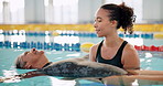 Trainer, senior woman and swimming in pool for rehabilitation with retirement, floating and health. Elderly lady, coach and help with water balance for hydrotherapy, aquatic training and wellness