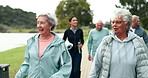 Friends, walking and senior people in park outdoors together for bonding, fitness and relax in nature. Retirement, happy and men and women in conversation for wellness, health and active lifestyle