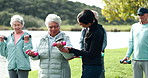 Fitness, dumbbells and old people in park with help, personal trainer and wellness  in muscle training. Physio, woman and group of senior friends on grass for workout, stretching or mobility exercise