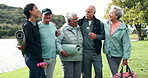 Woman, coach and park with group of senior people in huddle, fitness or motivation with exercise mat. Scrum, support and hug with laughing at comic joke at training, workout and memory in retirement