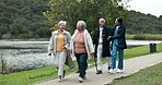 Assisted living, community and nurse walking with old people outdoor together for activity. Healthcare, friends or fresh air and senior group in garden with happy caregiver for medical wellness