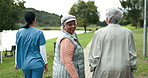 Assisted living, community or walking with nurse and old women outdoor together for activity. Healthcare, friends and smile of senior person in garden with happy caregiver for wellness from back