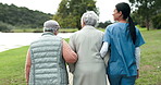 Back, community and nurse walking with old women in garden together for activity. Assisted living, community or retirement and senior friends outdoor with happy caregiver for medical wellness