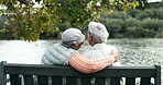 Elderly, women and back with hug on park bench by lake for support, bonding and embrace with love for companion. Senior female friends, outdoor and relax in environment for caring and empathy.