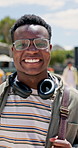 Happy student, black man and walking with headphones or bag for education, learning journey or future ambition at campus. Portrait of young African, male person or smile for scholarship at college