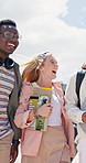 Walking, happy and students together in outdoor with friends on campus for learning, academic scholarship and education. Diversity, backpack and college for knowledge, opportunity and development.