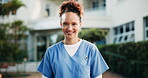 Nurse, face and happy outdoor with smile or pride at hospital for healthcare, wellness and career. Female employee, woman and confident outside of clinic for health, nursing and medical service