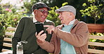 Bench, funny and senior men with smartphone, humor and relax with retirement, smile and connection. Outdoor, happy people and friends in park, cellphone and laughing for meme, joke and online comedy