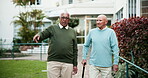 Senior men, walking and pointing in retirement home as friends, partner or community in conversation. Elderly people, bonding and support in outdoor of nursing village with discussion, chat and unity