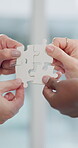 Business people, hands and teamwork with puzzle for problem solving, synergy and integration in office. Employee engagement, group and jigsaw piece for partnership, solution and company interaction