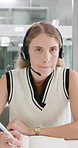 Woman, consultant and writing with headphones at call center for customer service or report at office. Portrait or pov of young female person or agent taking notes with book and mic for online help