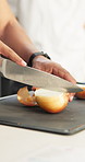 Kitchen, hands and knife with onion for chop, cut and food preparation technique for fine dining on table. Culinary, person and professional cook with fresh vegetable, hospitality and cooking skills