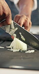 Kitchen, hands and knife with onion for cut, chop and food preparation technique for fine dining on table. Culinary, person and professional chef with raw vegetable, hospitality and cooking skills