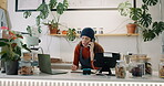 Small business, cafe and woman or cashier on telephone with conversation and taking notes for order. Female owner, waitress and laptop on counter in lifestyle store or shop with communication