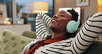 Black woman, headphones and relax on sofa with smile, listening and music with streaming in home living room. Person, happy and excited for subscription, audio and relief on couch with peace in house