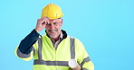 Face, hard hat and man with blueprints, engineering and project manager on blue studio background. Portrait, person and model with helmet, smile and documents for renovation, industry or architecture
