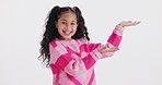 Girl, open hands and face in studio with space for mock up with smile, choice or show by white background. Child, happy and excited with palm for decision, fashion or review  in portrait with clothes