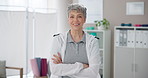 Mature woman, physiotherapist and arms crossed in clinic with confidence for physical therapy or recovery service. Chiropractor portrait, person and happy at workplace for rehabilitation and wellness