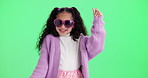 Girl, dancing and child with sunglasses by green screen with smile, funny and games by background. Kid, happy and playful with heart shape, comic and fashion for fantasy with emoji by mockup space