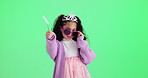 Girl, child and face with sunglasses by green screen with smile, funny or dance by studio background. Kid, princess and wand with crown, power and playful for fantasy with fashion by mock up space