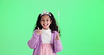 Girl, princess and thumbs up by green screen in studio with wand, face and games by background. Excited kid, magic and happy with crown, toys and spell with fun, fantasy and playful by mock up space