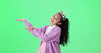 Pointing, green screen and face of child in crown for promotion, bargain and discount news. Princess tiara, fashion and portrait of isolated young girl with hand gesture for announcement on chromakey