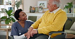 Medical, man in wheelchair and nurse talking in living room of retirement home for advice or consulting. Assisted living, conversation and woman caregiver speaking to senior patient with disability