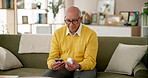 Senior, man and medication in home with smartphone, telehealth app and research side effects for safety. Sofa, lounge and pharmaceutical info for healthcare, pill and container for faq online