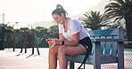 Tennis player, woman and relax with phone on court for text message, communication or social media scroll. Sports, athlete and break on bench with online fitness app, game research and mobile chat